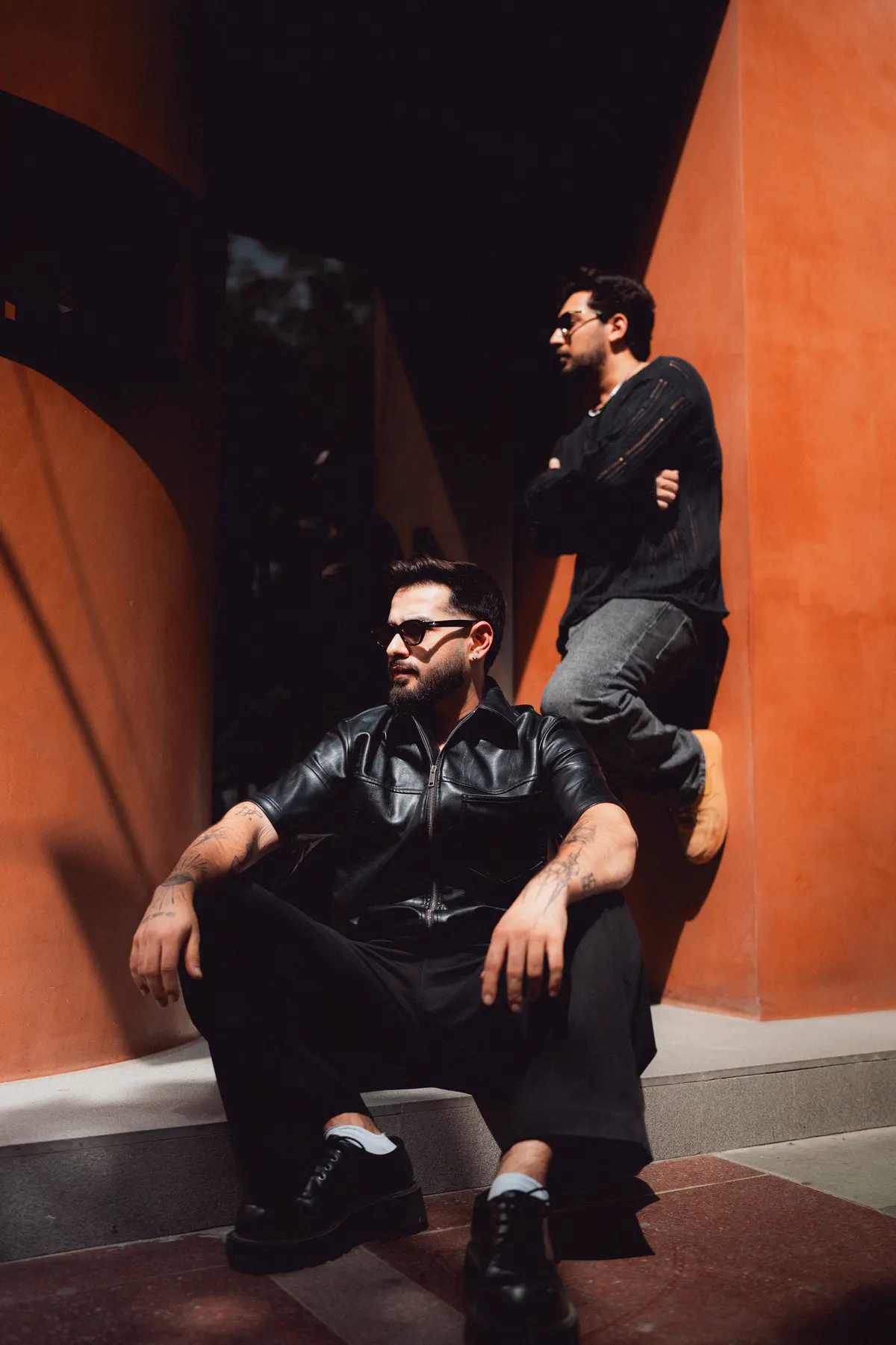 Ekansh and Sahil against a burnt-orange wall