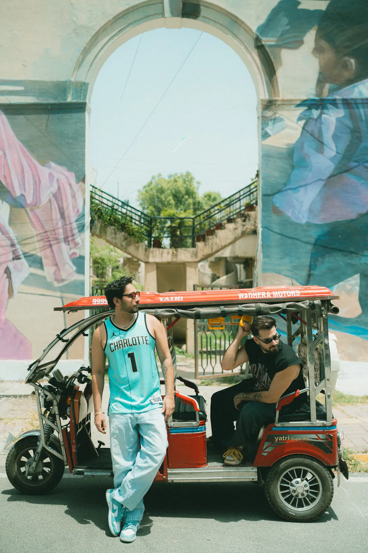 With an e-rickshaw under a painted arch